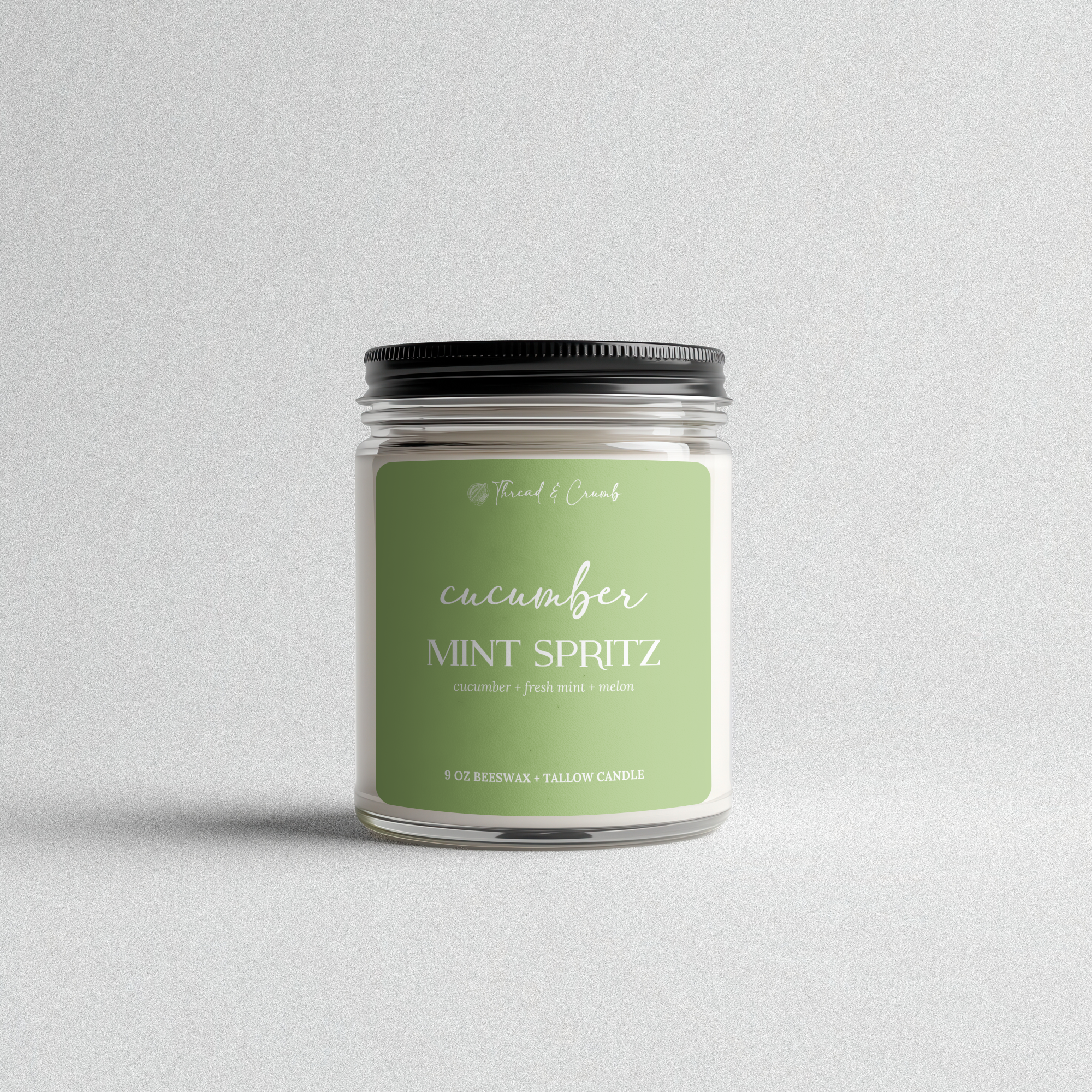 Front view of the handmade Cucumber Mint Spritz beeswax and tallow candle in a clear glass jar.
