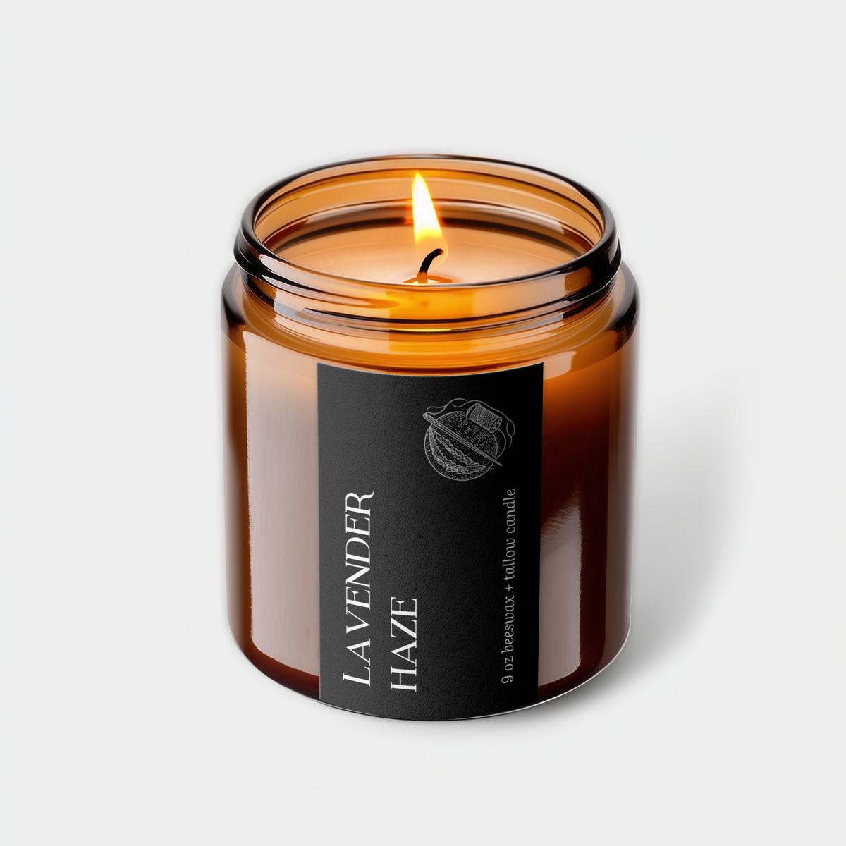 Lavender Haze beeswax and tallow candle in an amber glass jar with a black label and lit cotton wick