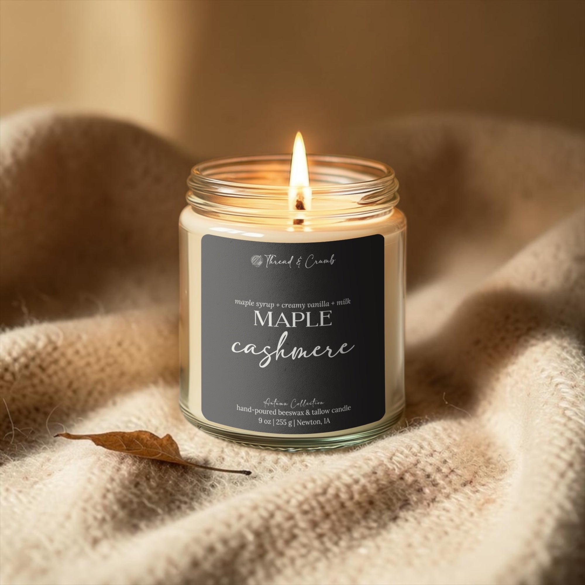 Maple Cashmere maple vanilla fall candle styled on a soft knit blanket.