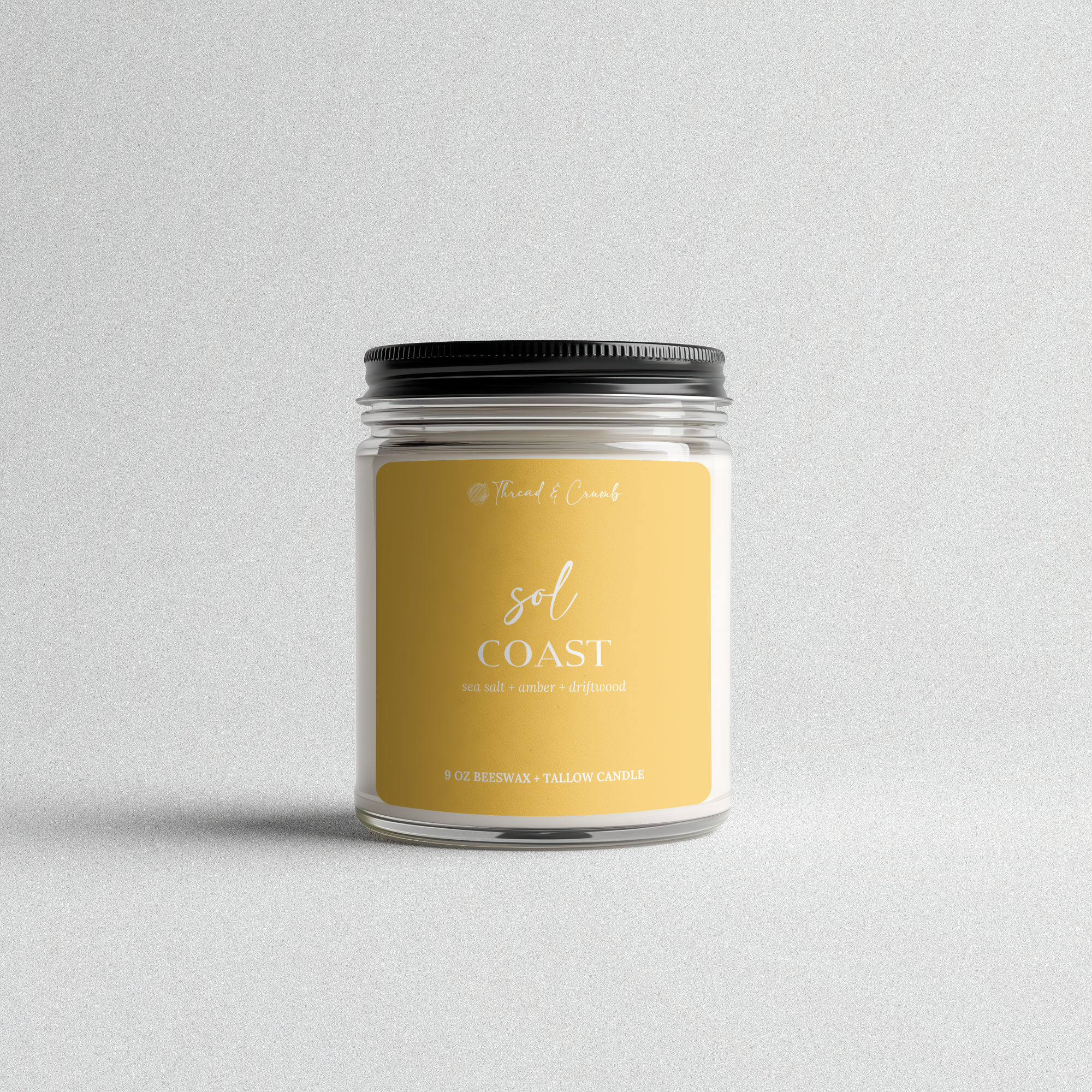 Front view of the handmade Sol Coast beeswax and tallow candle in a clear glass jar.
