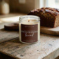 Spiced Banana Bread beeswax and tallow candle with banana bread loaf on a warm rustic kitchen table