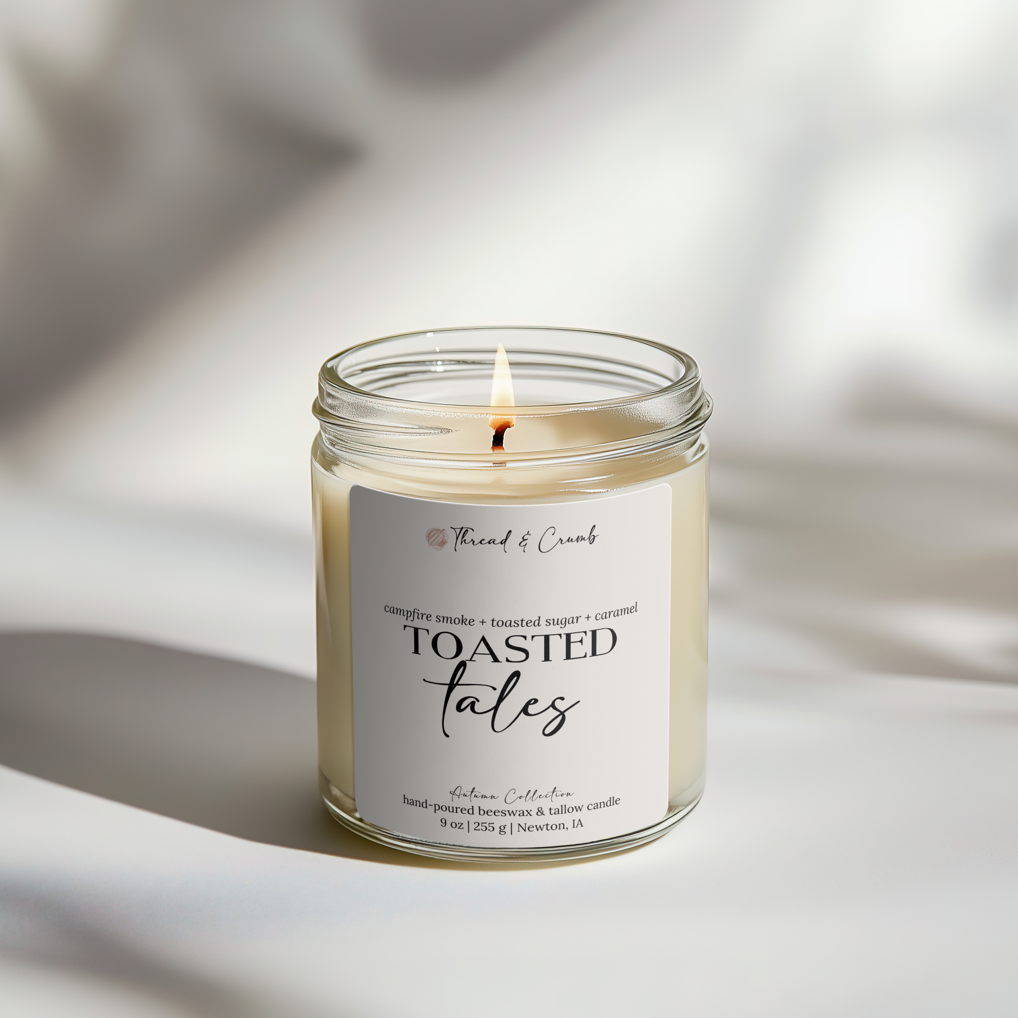 Front view of the handmade Toasted Tales beeswax and tallow candle in a clear glass jar.